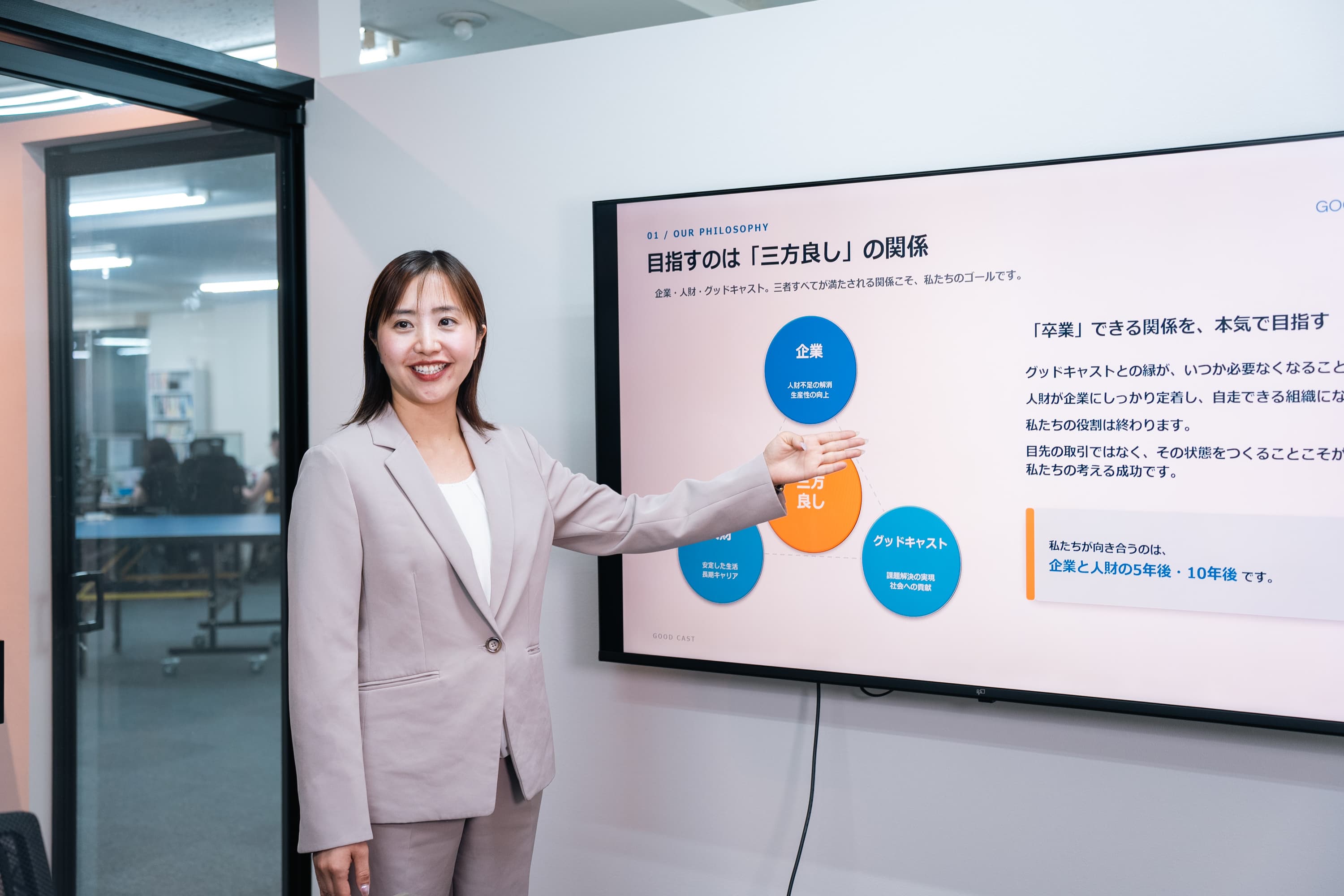 画面の資料を使って会社の考え方を説明するメンバー